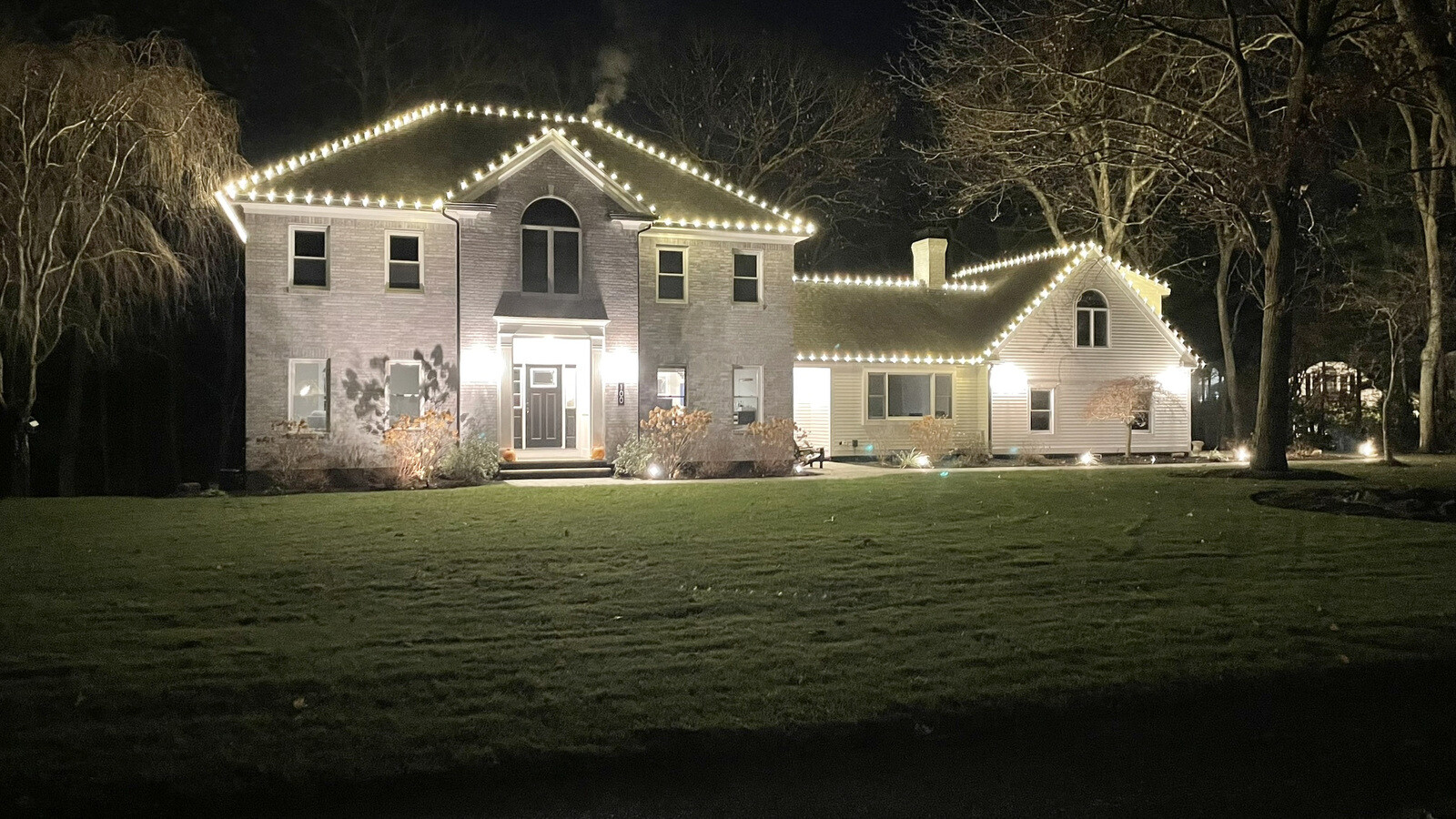 A home and street beautifully lit for Christmas at night